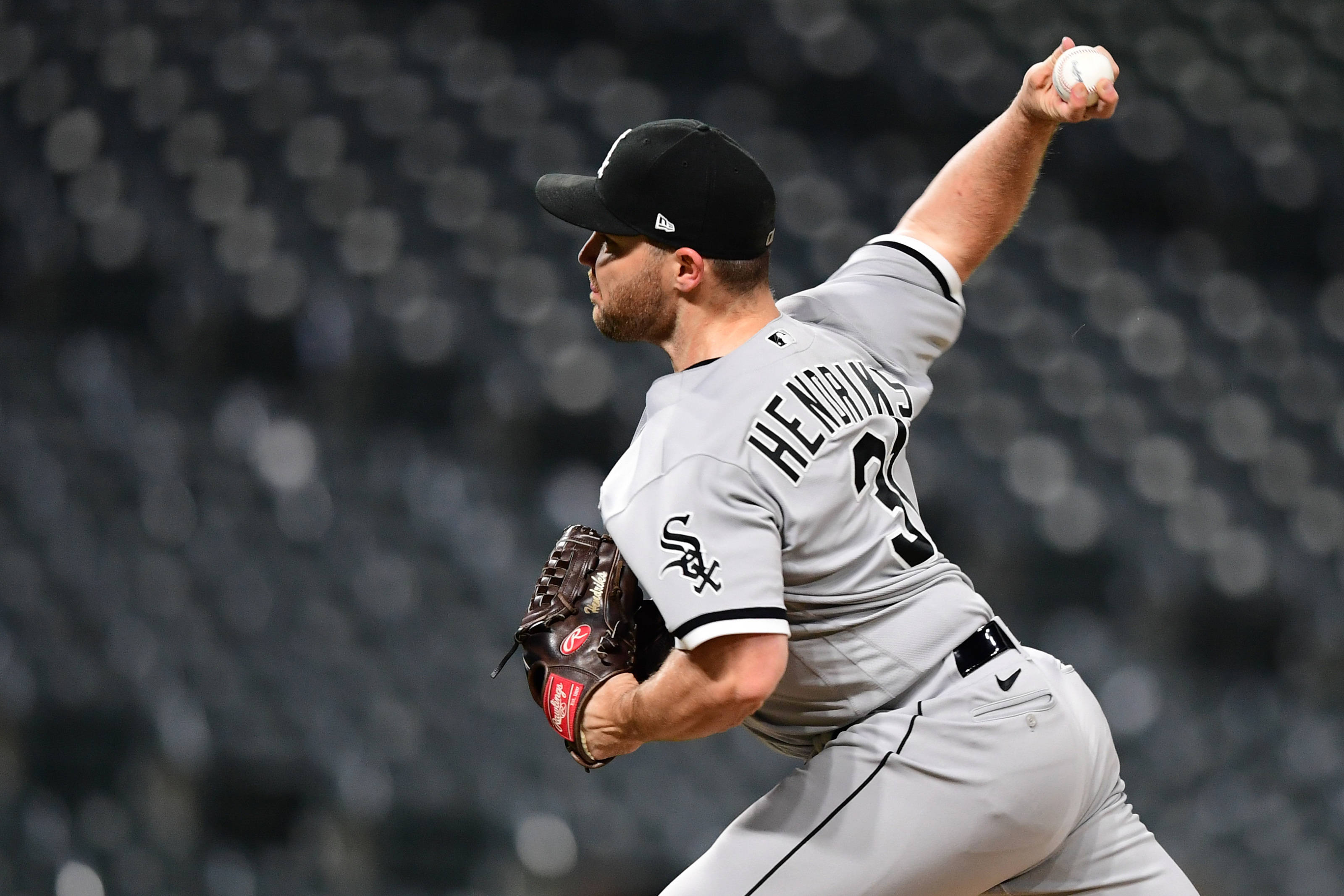 利亞姆·亨德里克斯投球 壁紙 — 一位身穿灰色Sox球衣的棒球投手，在球場燈光下全神貫注地投球。