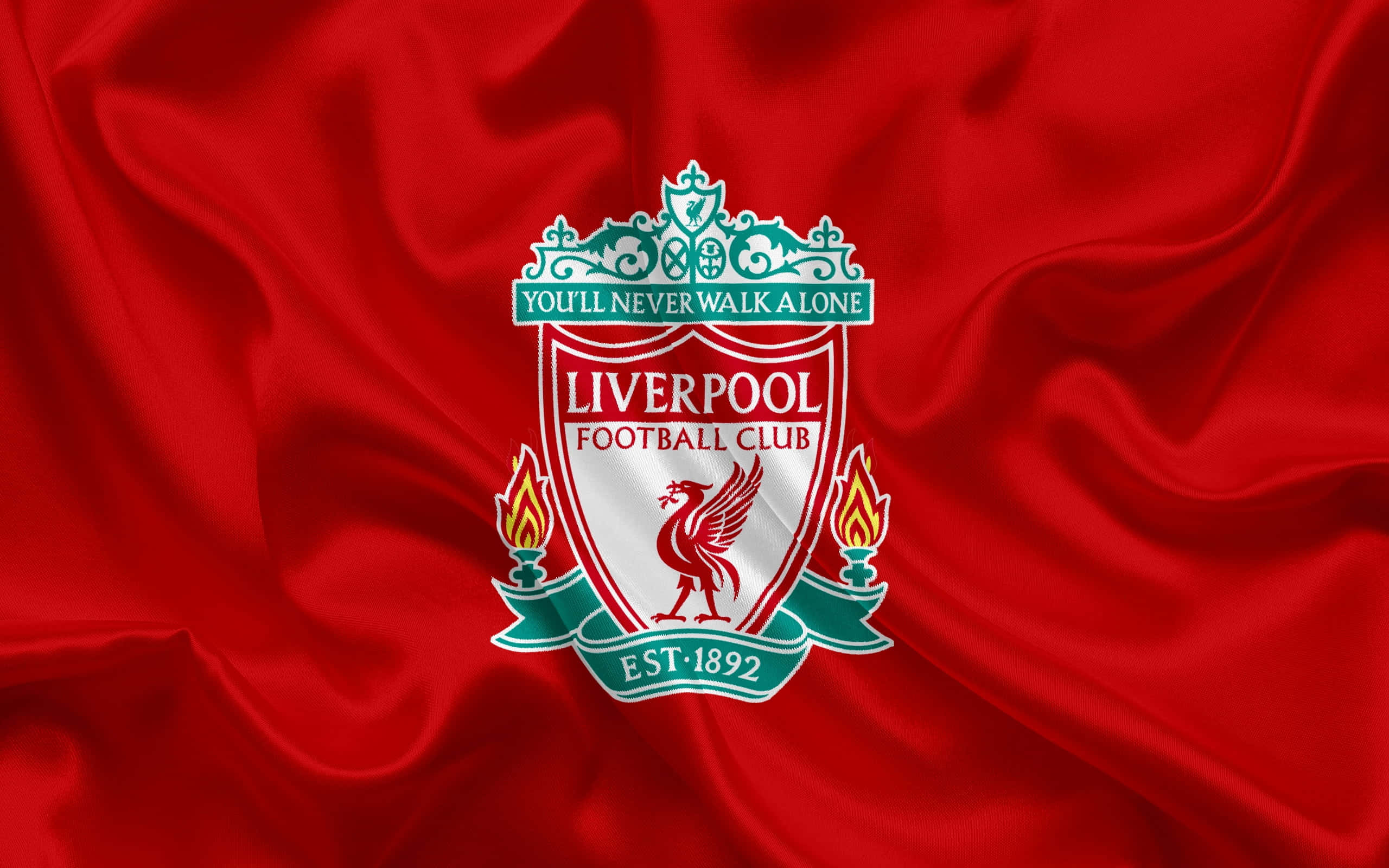 Liverpool Logo 桌布 壁紙 — 利物浦足球會會徽在豪華的紅色緞面布料上閃耀著鮮豔的紅色和綠色，帶有流暢的褶皺。