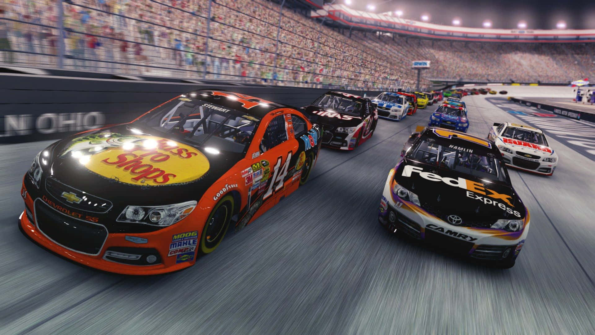 NASCAR賽車在夜間繞著體育場賽道飛馳。