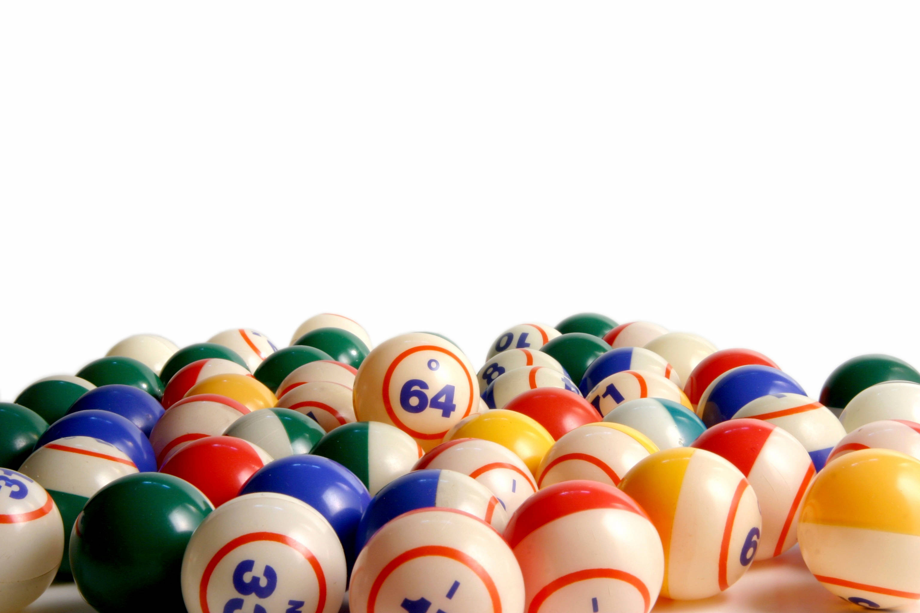 刺激的機會遊戲——賓果球集合 壁紙 — 一堆色彩繽紛、帶有數字的桌球散落在純白背景上。