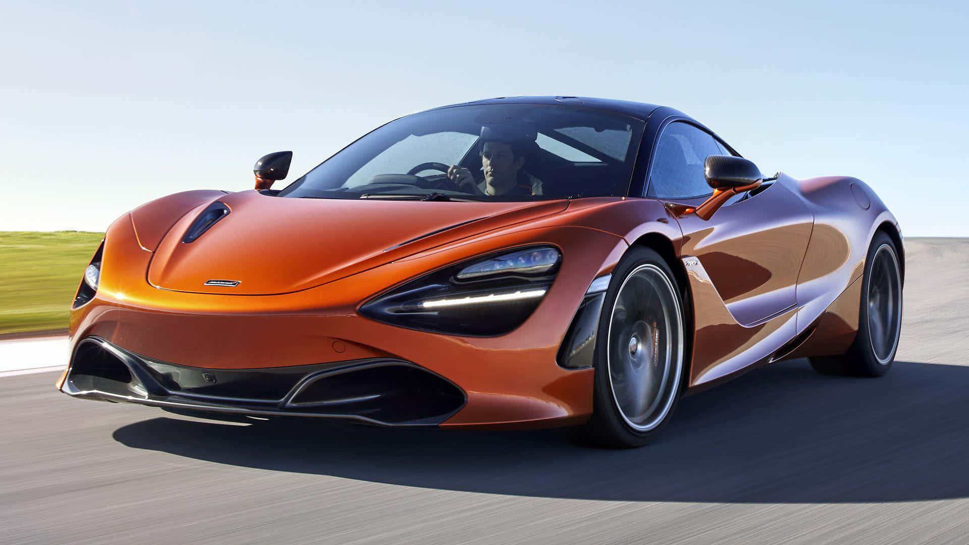 橙色McLaren 720S在賽道上疾馳，駕駛員清晰可見。
