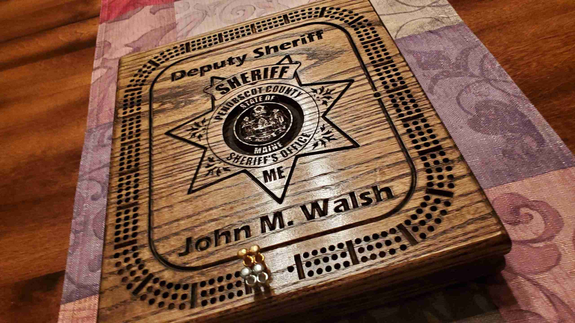 刻有副警長星章和名字 John M Walsh 的木製餅乾盒。