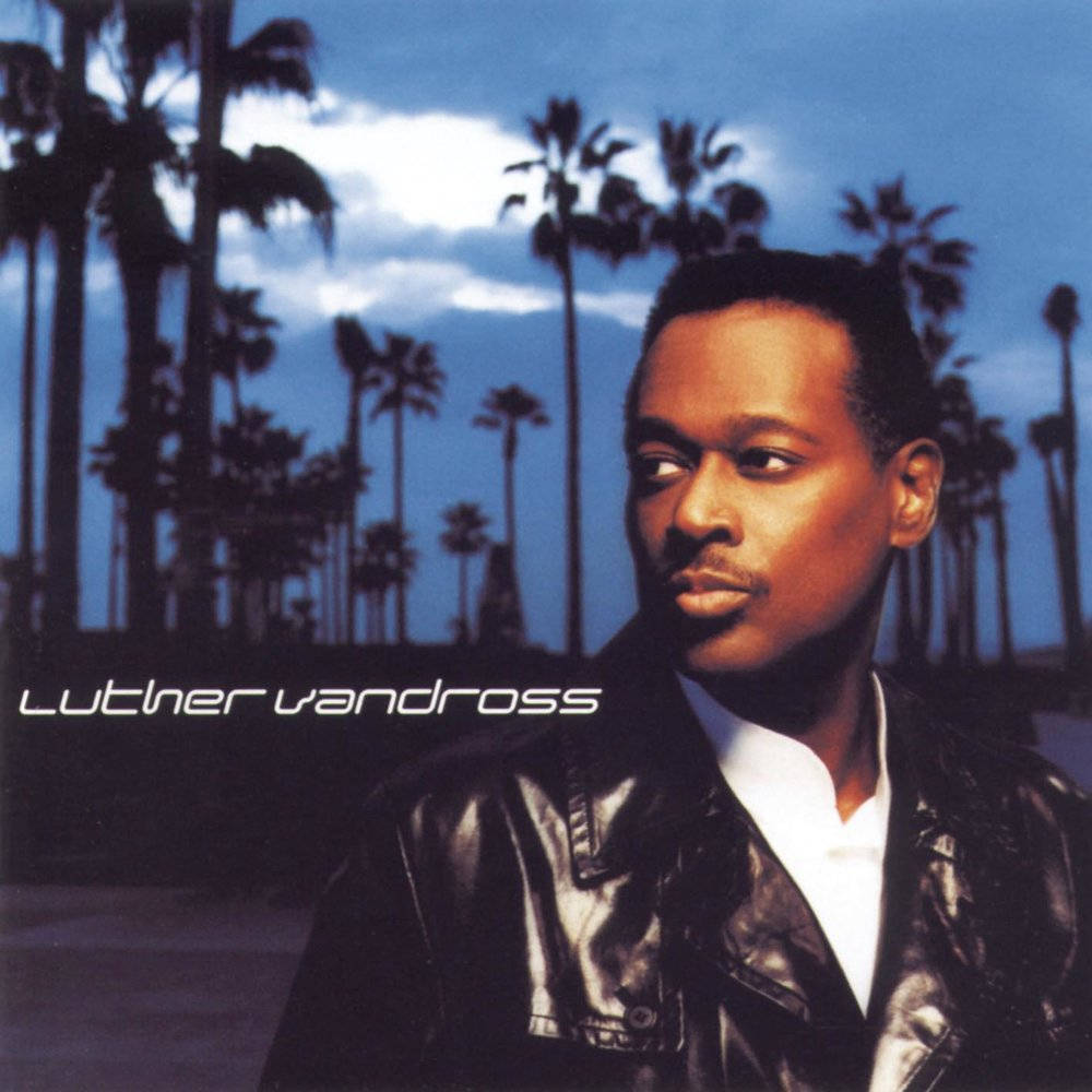 創作歌手盧瑟·凡德羅斯海報 壁紙 — Luther Vandross 身穿黑色皮褸，在暮色天空下的棕櫚樹背景下若有所思地凝視。