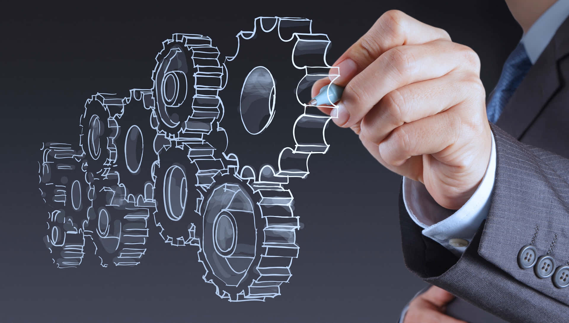 手在屏幕上繪製齒輪以代表商業策略和技術。