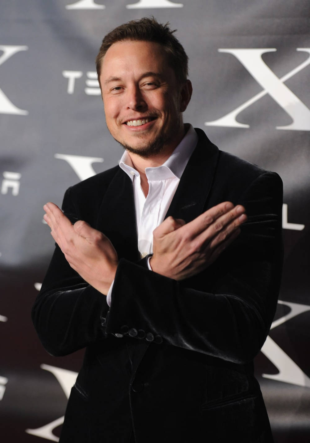 伊隆·馬斯克在Tesla活動中穿著黑色天鵝絨西裝鼓掌。