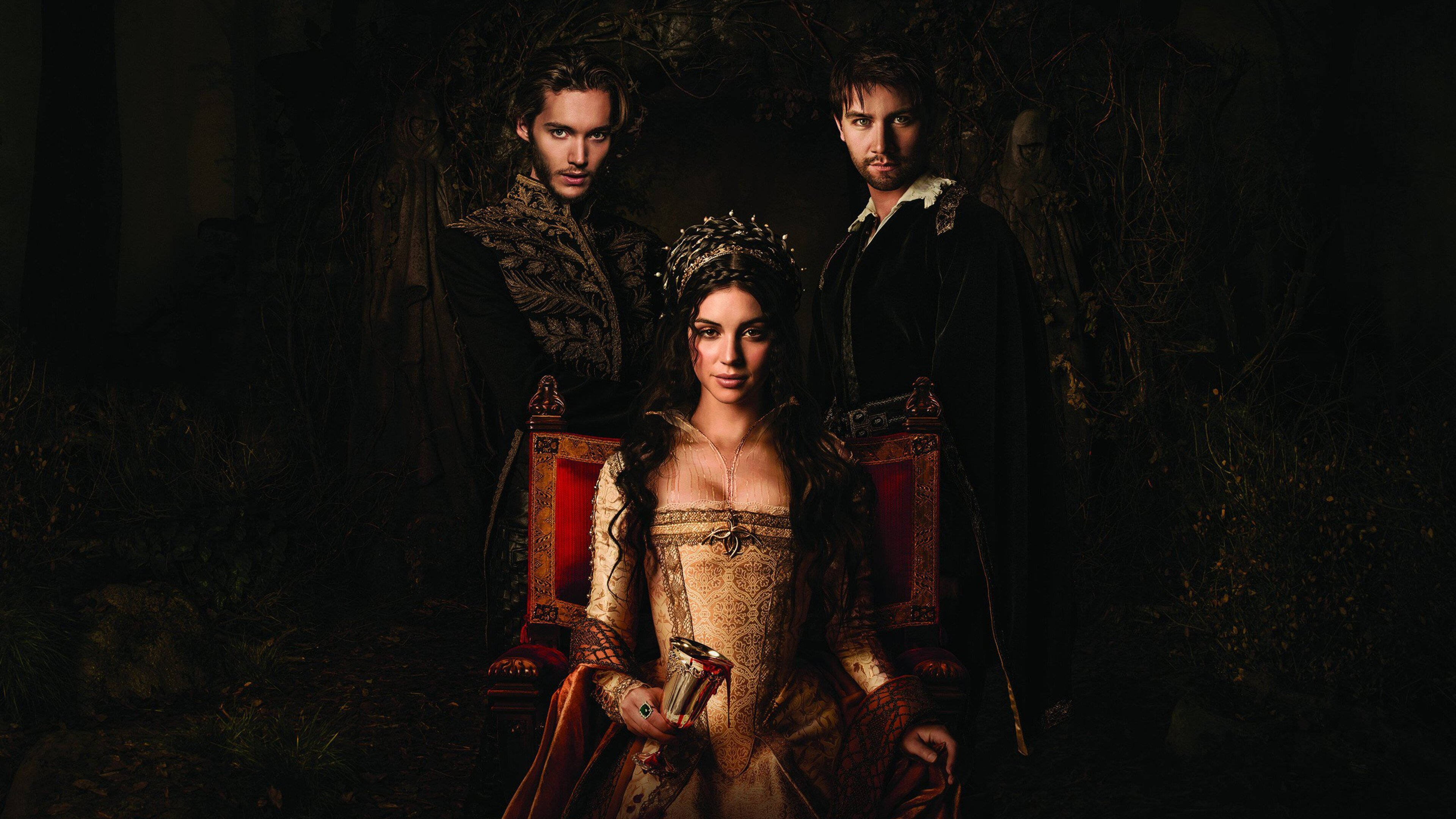 劇集《Reign》瑪麗·斯圖亞特女王與她的王子們 壁紙 — 三個穿著華麗時代服裝的人物在黑暗的森林中與王座一起戲劇性地擺姿勢，被聚焦的光線照亮。