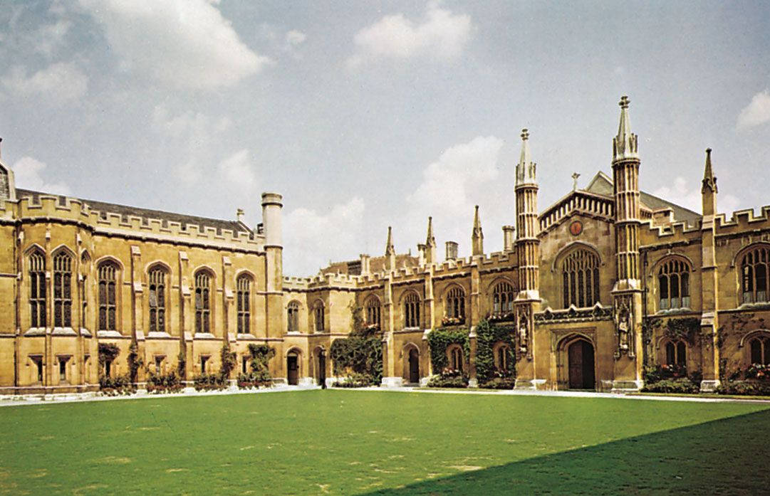哥德式大學庭院，擁有石頭建築和綠色草坪。