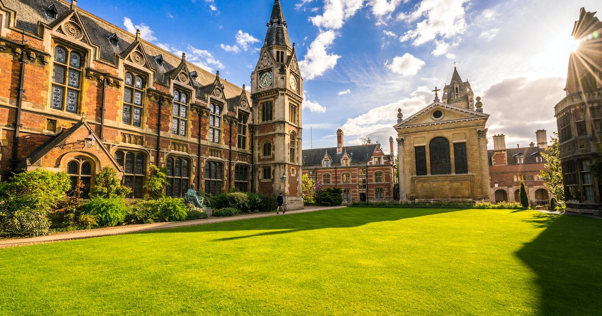 寬敞的大學庭院，哥德式建築，陽光下的翠綠草坪。