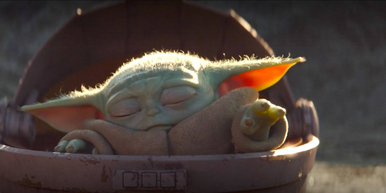 Baby Yoda 在金屬籃子裡睡覺，陽光照射在耳朵上