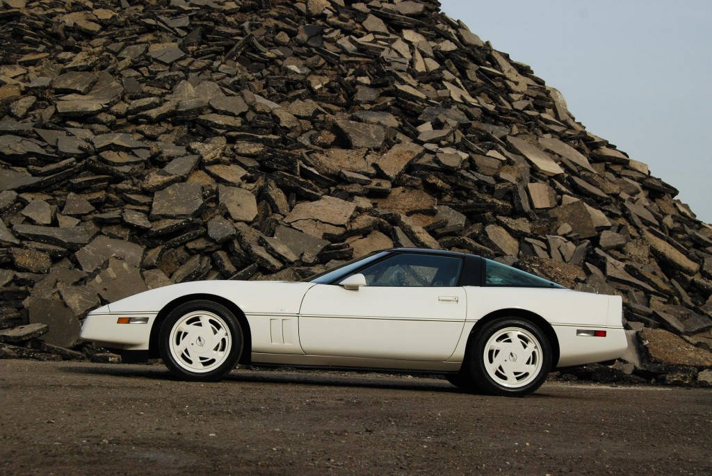 白色經典Corvette停泊在一個大石堆旁邊。