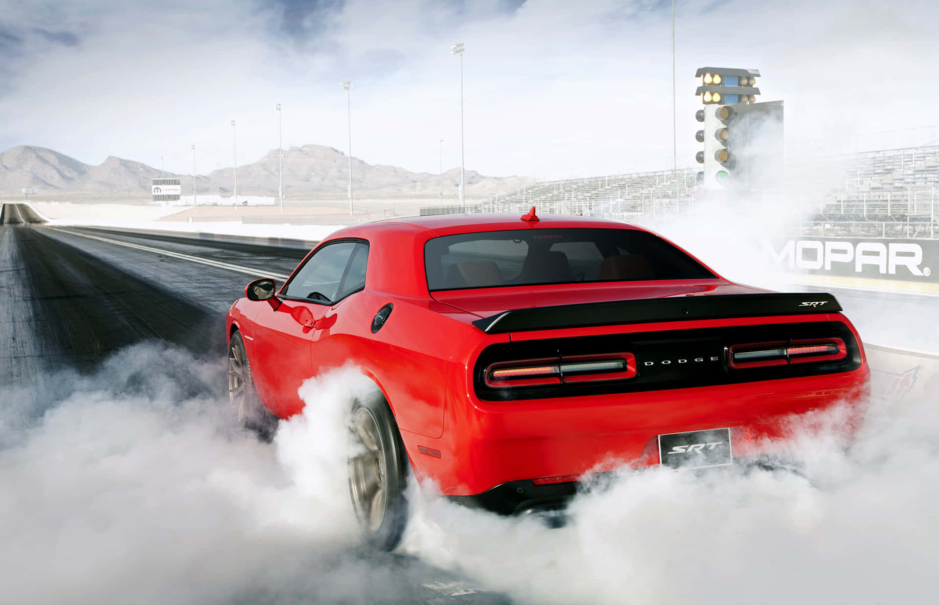紅色Dodge Challenger SRT在沙漠賽道上燒胎。
