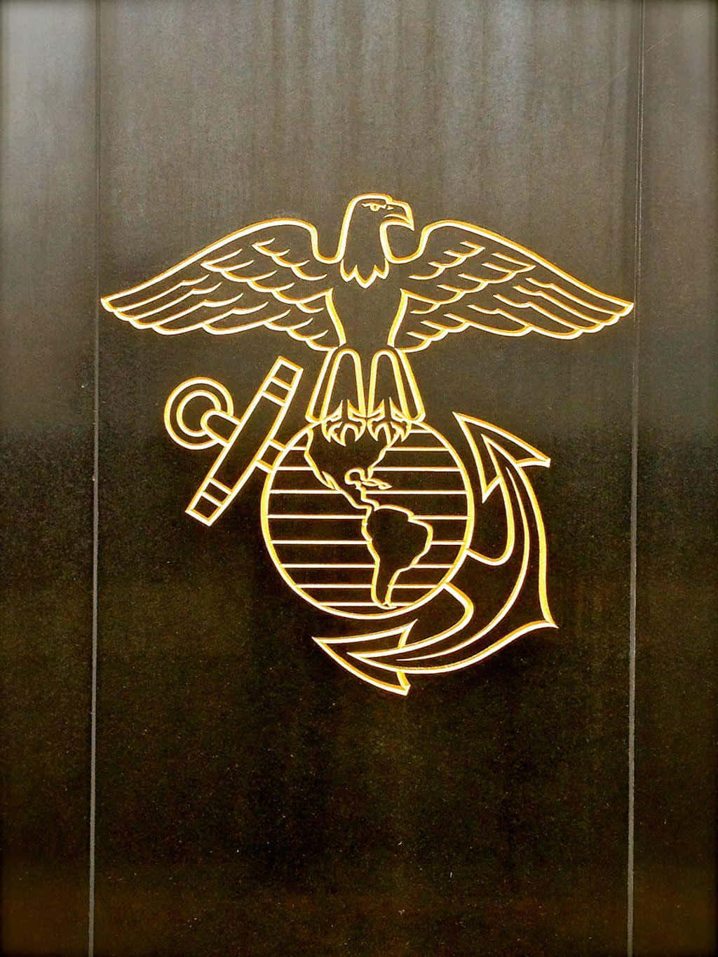 力量與榮譽的軍隊 壁紙 — 金色海軍陸戰隊徽章，刻有鷹、地球和錨，蝕刻在深色木板上。