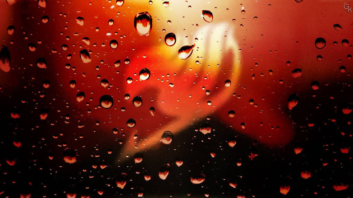 玻璃上的雨滴，背景是熾熱的日落。