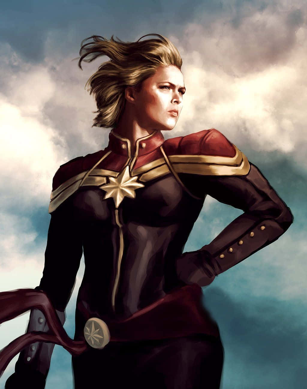 加入漫威復仇者聯盟的壯闊電影冒險 壁紙 — Captain Marvel 自信地站在戲劇性的多雲天空下，風吹動她的頭髮。