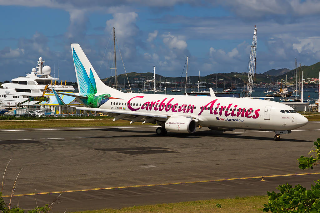 加勒比航空飛機在跑道近遊艇和山丘