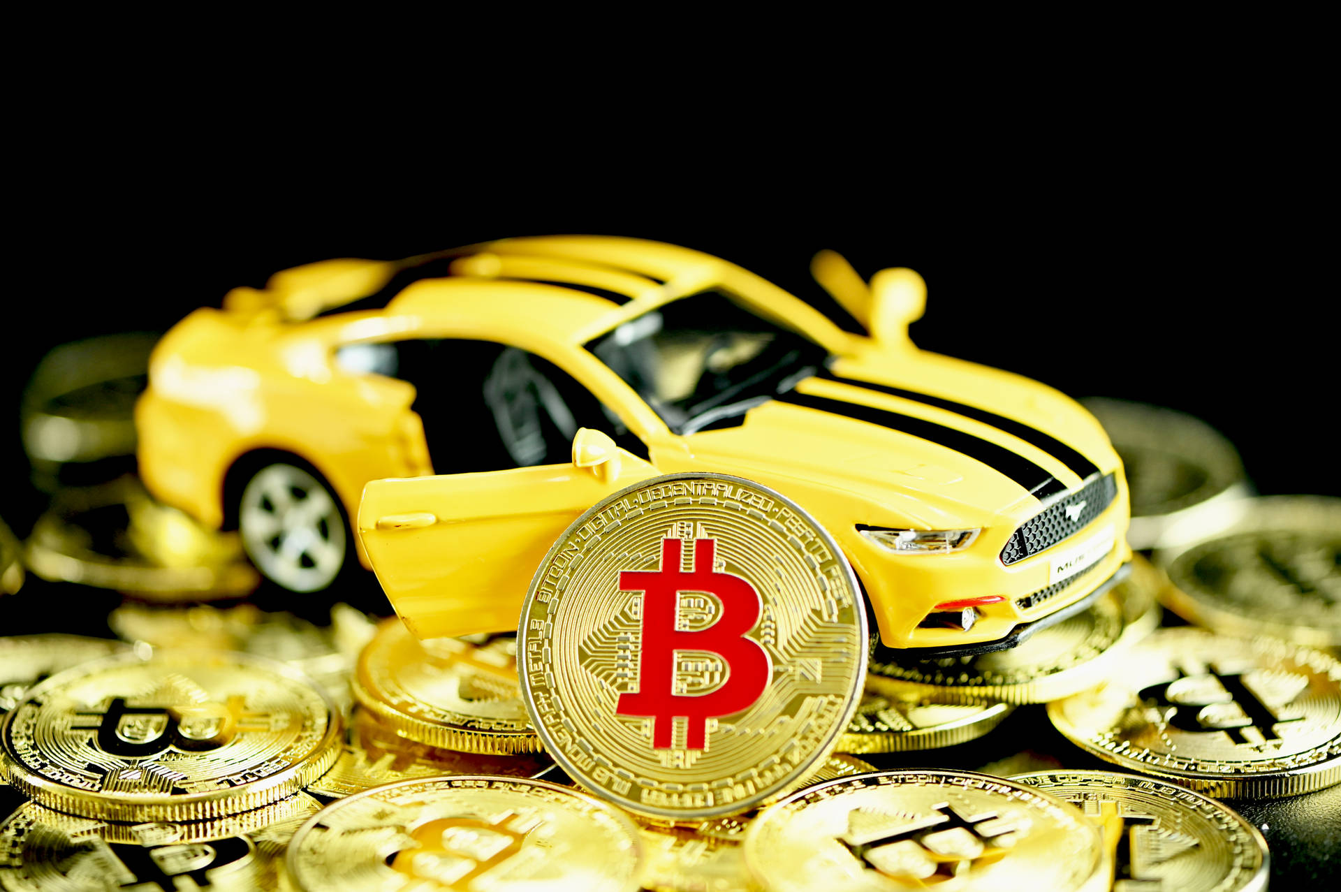 黃色玩具車被金色比特幣硬幣包圍。