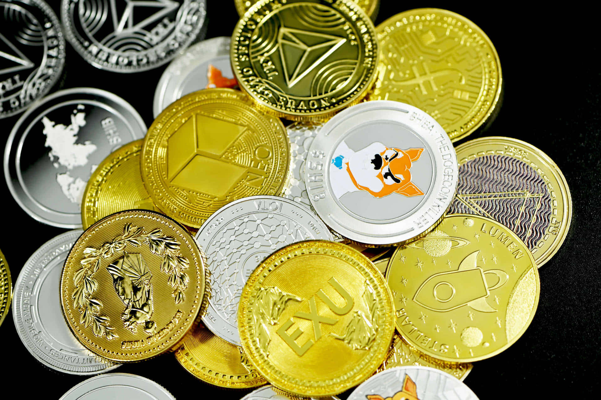 加密銀金硬幣 壁紙 — 一堆閃亮的金銀加密貨幣硬幣，帶有獨特標誌，散落在深色表面上。
