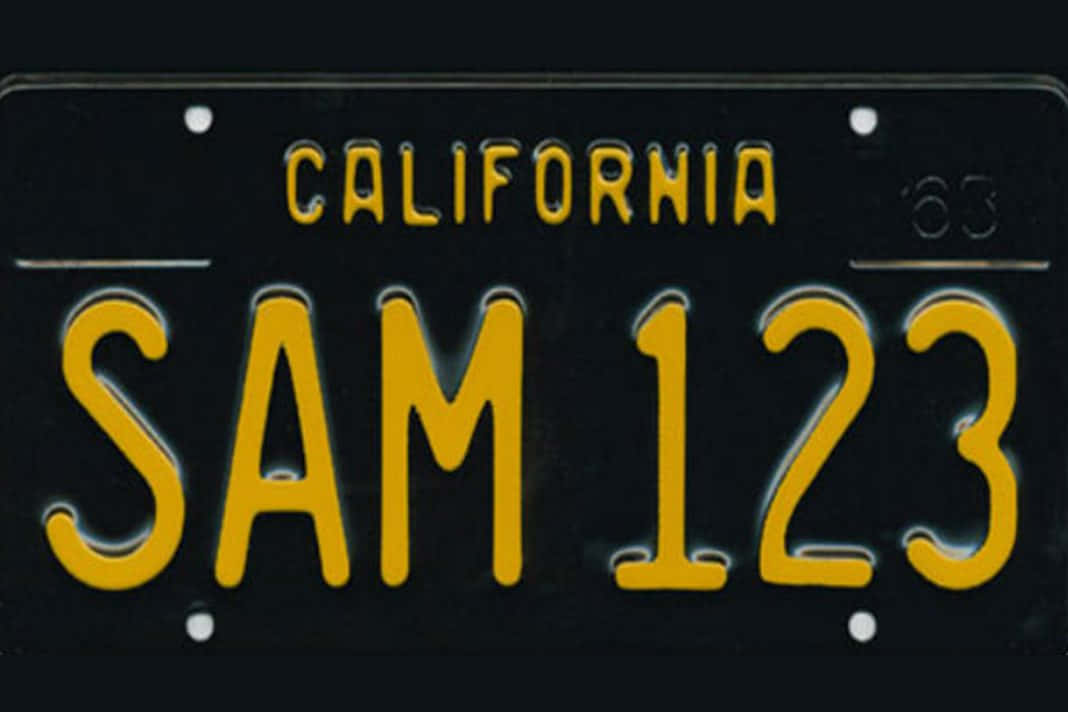 加州SAM 123車牌 壁紙 — 1963年加州復古車牌，黑色背景上帶有黃色「SAM 123」文字。