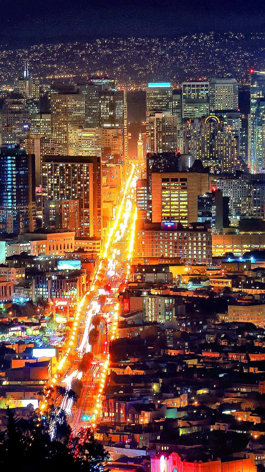 加州城市景觀 iPhone 壁紙 — 充滿活力的夜景城市景觀，發光的摩天大樓和流動的交通燈照亮了繁華的城市峽谷。