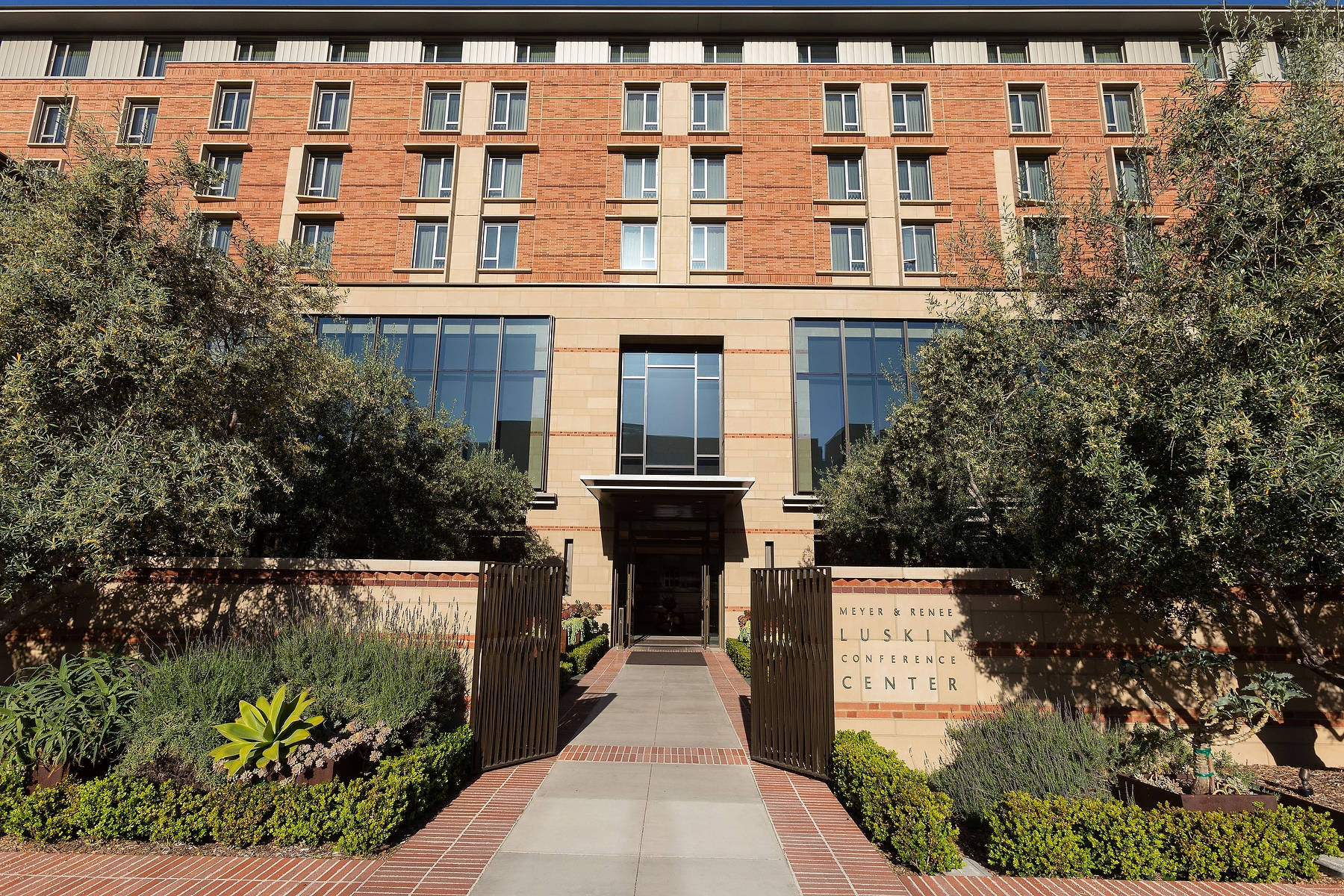 Meyer & Renee Luskin 會議中心入口，配有磚砌建築和園景花園。