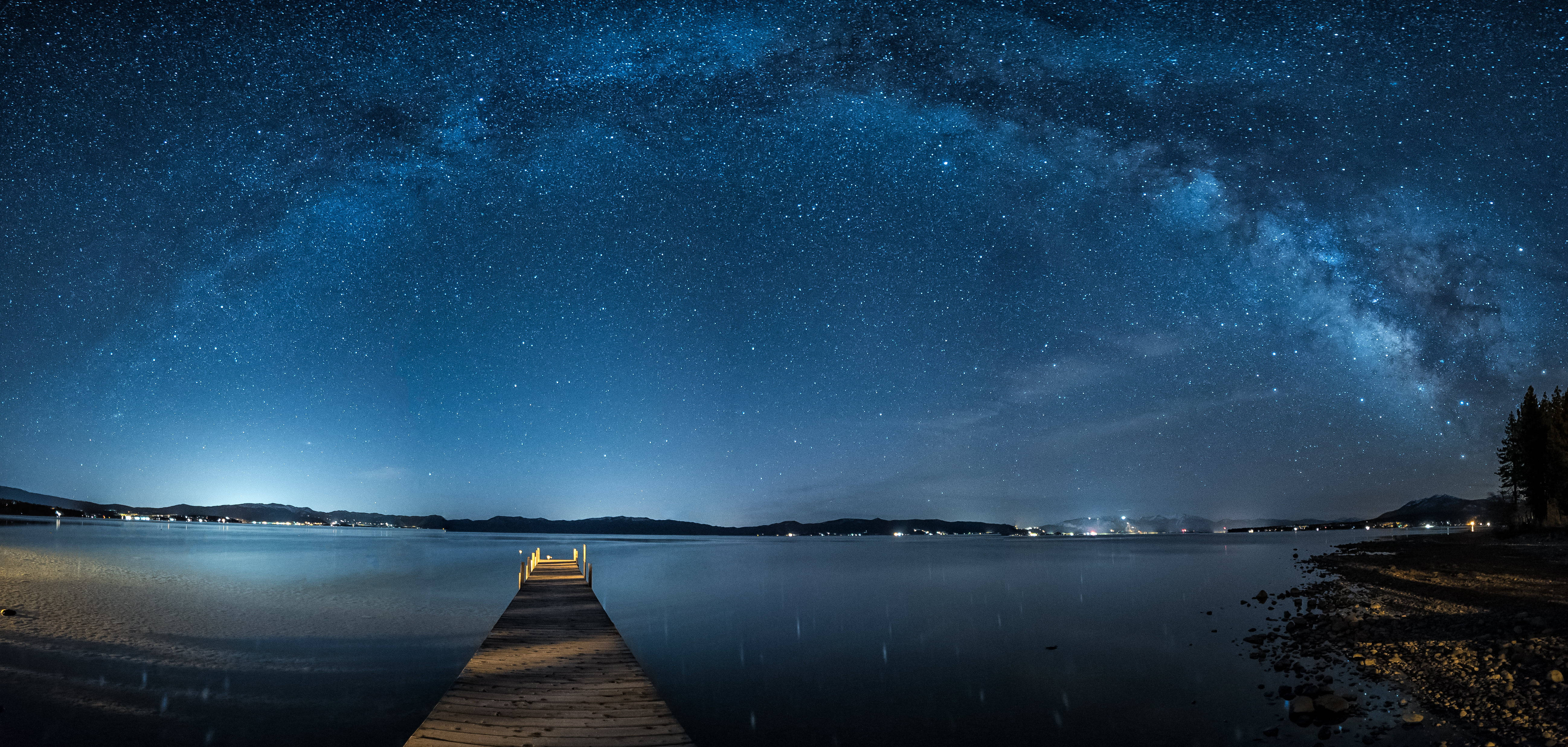 加州太浩湖夜景 壁紙 — 一個木製碼頭延伸到平靜的湖面上，上方是令人驚嘆的星空，銀河閃耀。