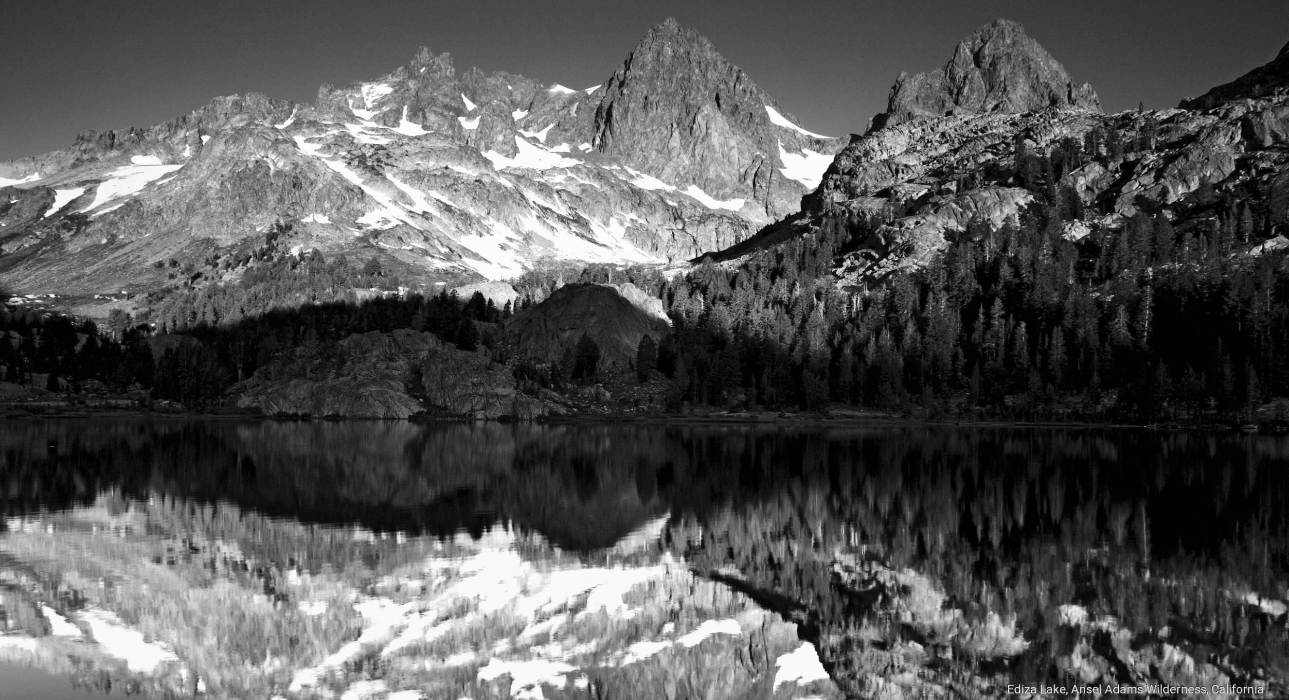 加州愛迪茲湖 壁紙 — 一個鮮明的黑白山湖場景，積雪的山峰完美地倒映在平靜的水面上，四周環繞著茂密的森林。