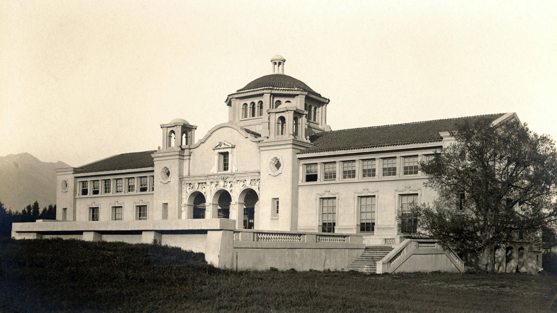 歷史建築，拱形入口和圓頂塔樓，位於青草山坡上。