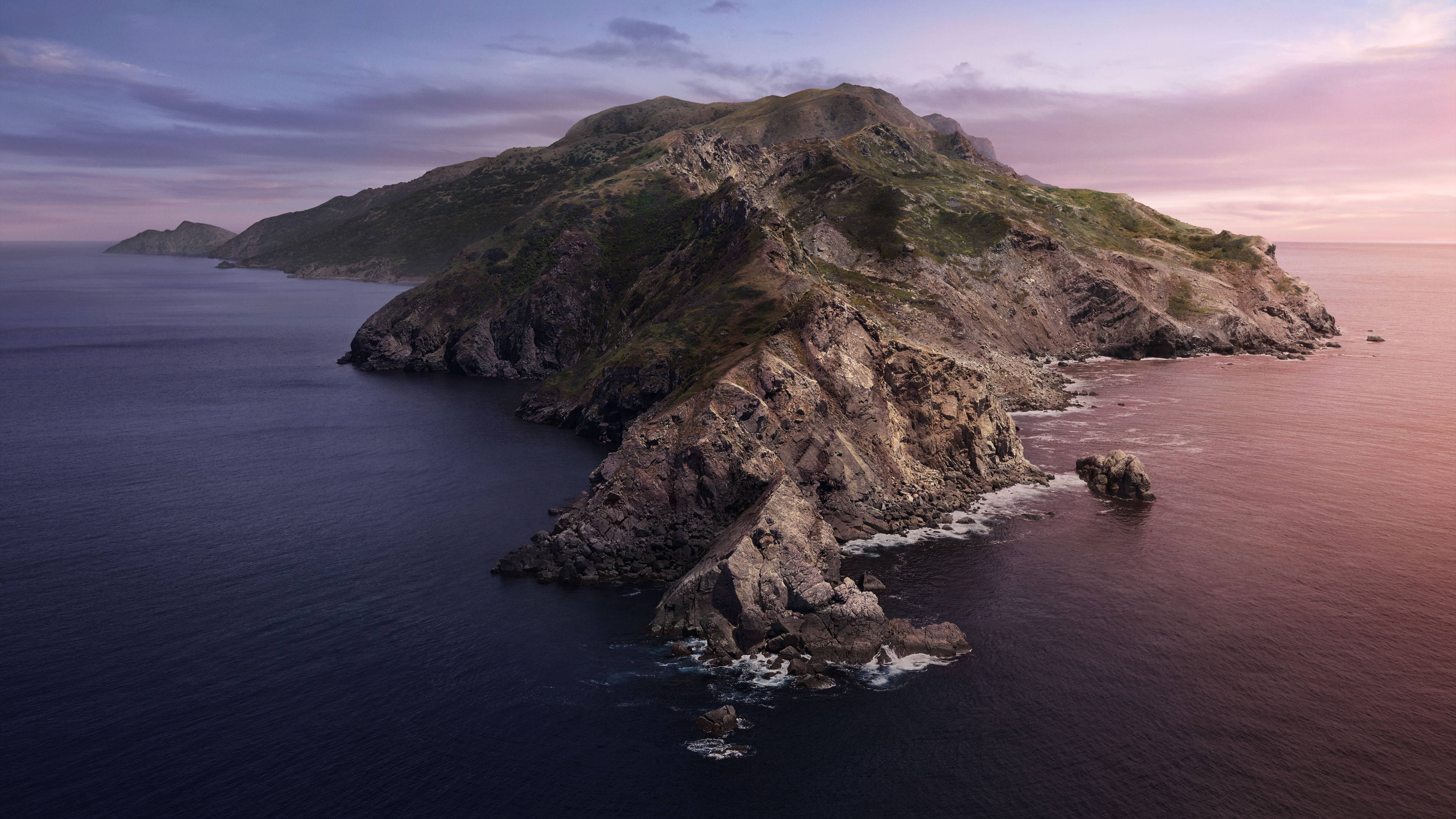 加州通道群島 壁紙 — 一個崎嶇的島嶼，有岩石峭壁和綠色斜坡，從深藍色的海水中升起，在柔和的粉紅色和紫色暮色天空下。