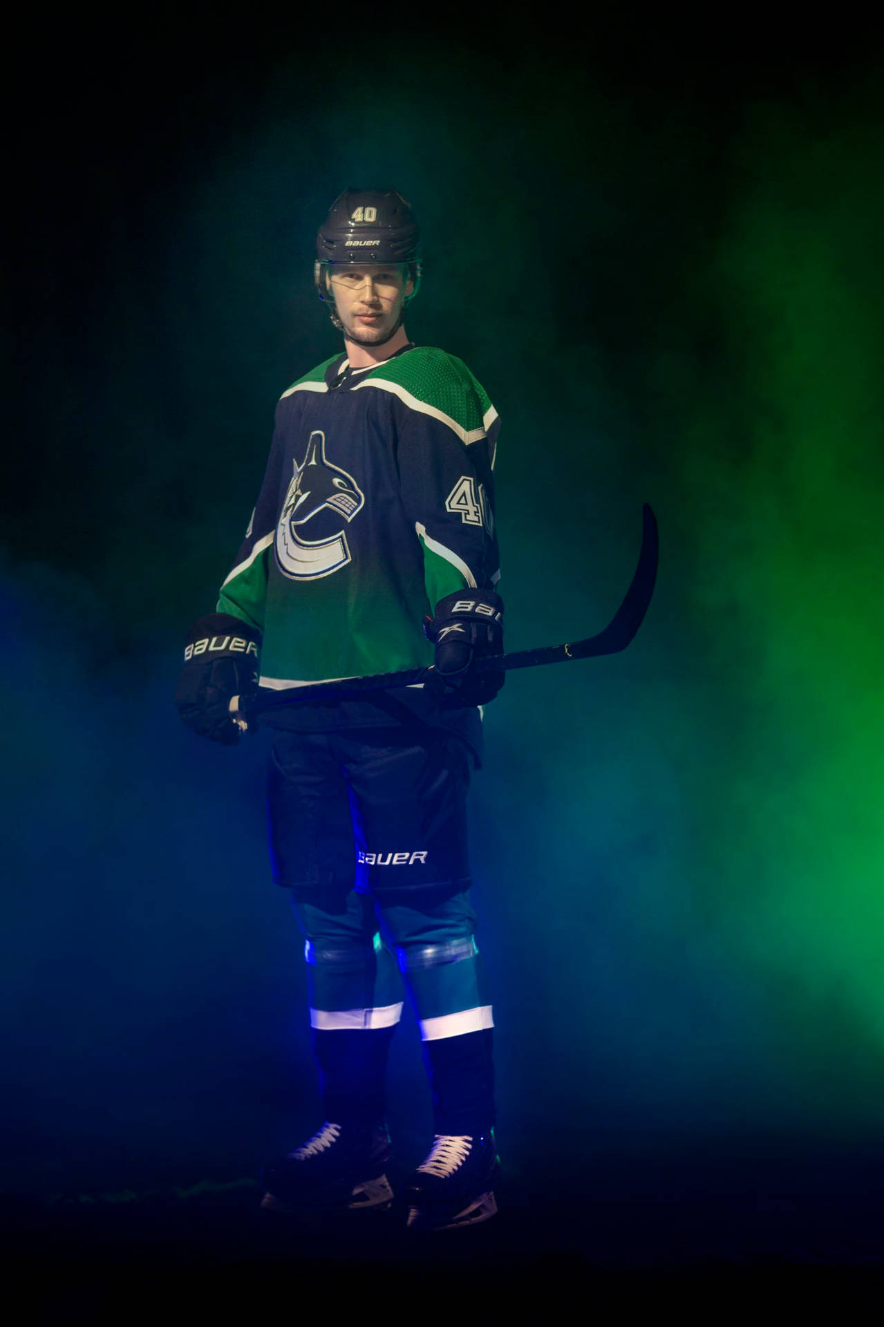 加拿大NHL球員伊萊亞斯·佩特ters森復古海報 壁紙 — 一名身穿綠色和藍色溫哥華加人隊球衣的曲棍球運動員，在煙霧瀰漫的黑暗背景下，手持球棍，被戲劇性的藍色和綠色燈光照亮。