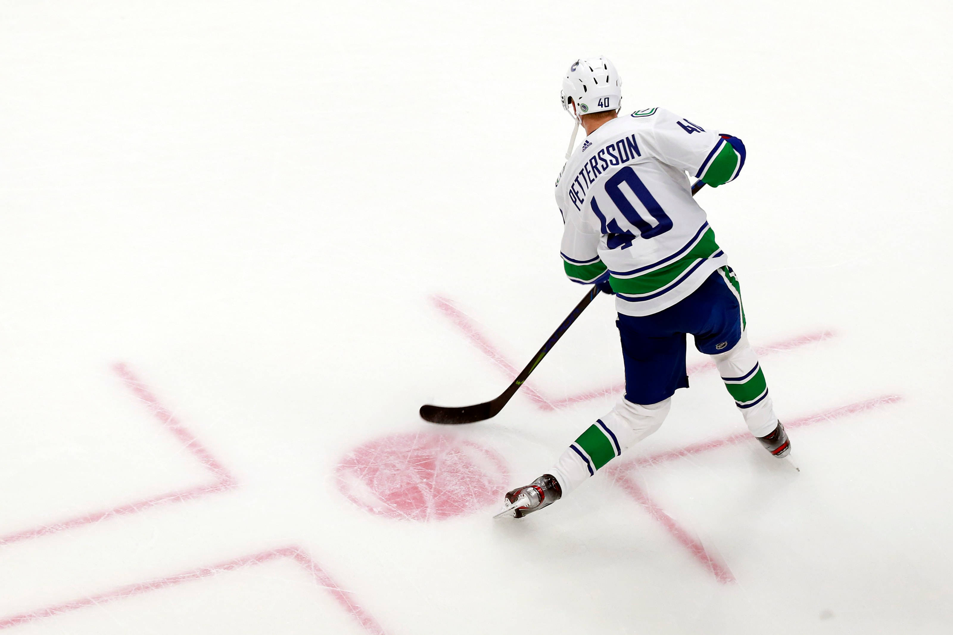 加拿大NHL球員伊萊亞斯·佩特ters森俯拍畫面 壁紙 — 冰球運動員40號在明亮的場館燈光下，在比賽中帶著冰球在冰上滑行。