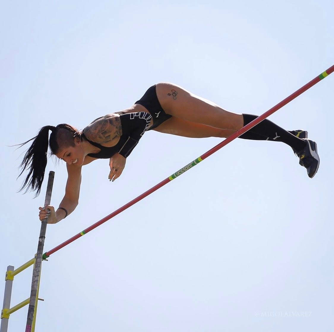 女運動員在半空中以撐竿跳越過跳高橫桿。