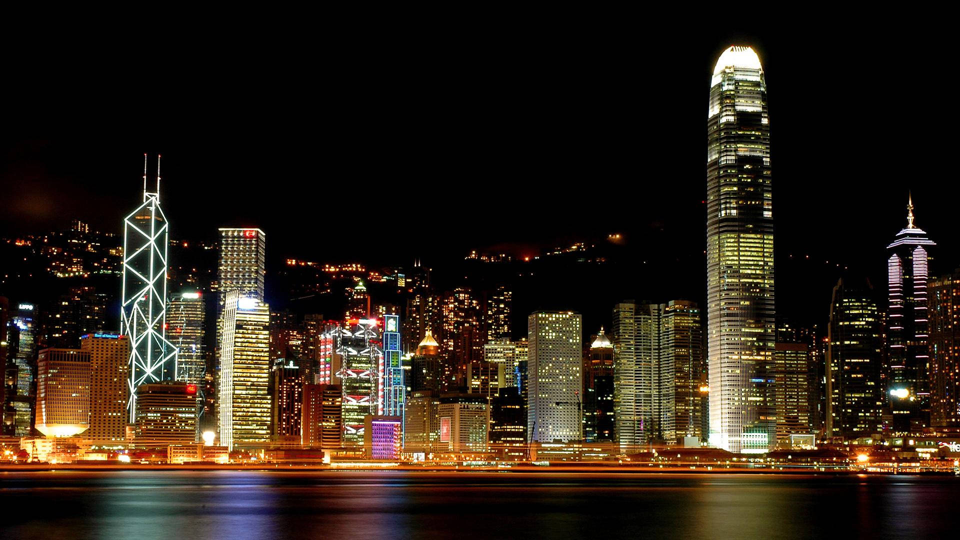 加拿大魁北克蒙特利爾暮色天際線 壁紙 — 香港天際線的迷人夜景，燈火通明的摩天大樓倒映在平靜的水面上。