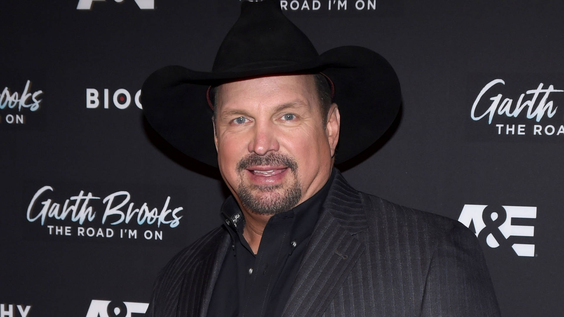Garth Brooks 在宣傳活動中戴著黑色牛仔帽和西裝。