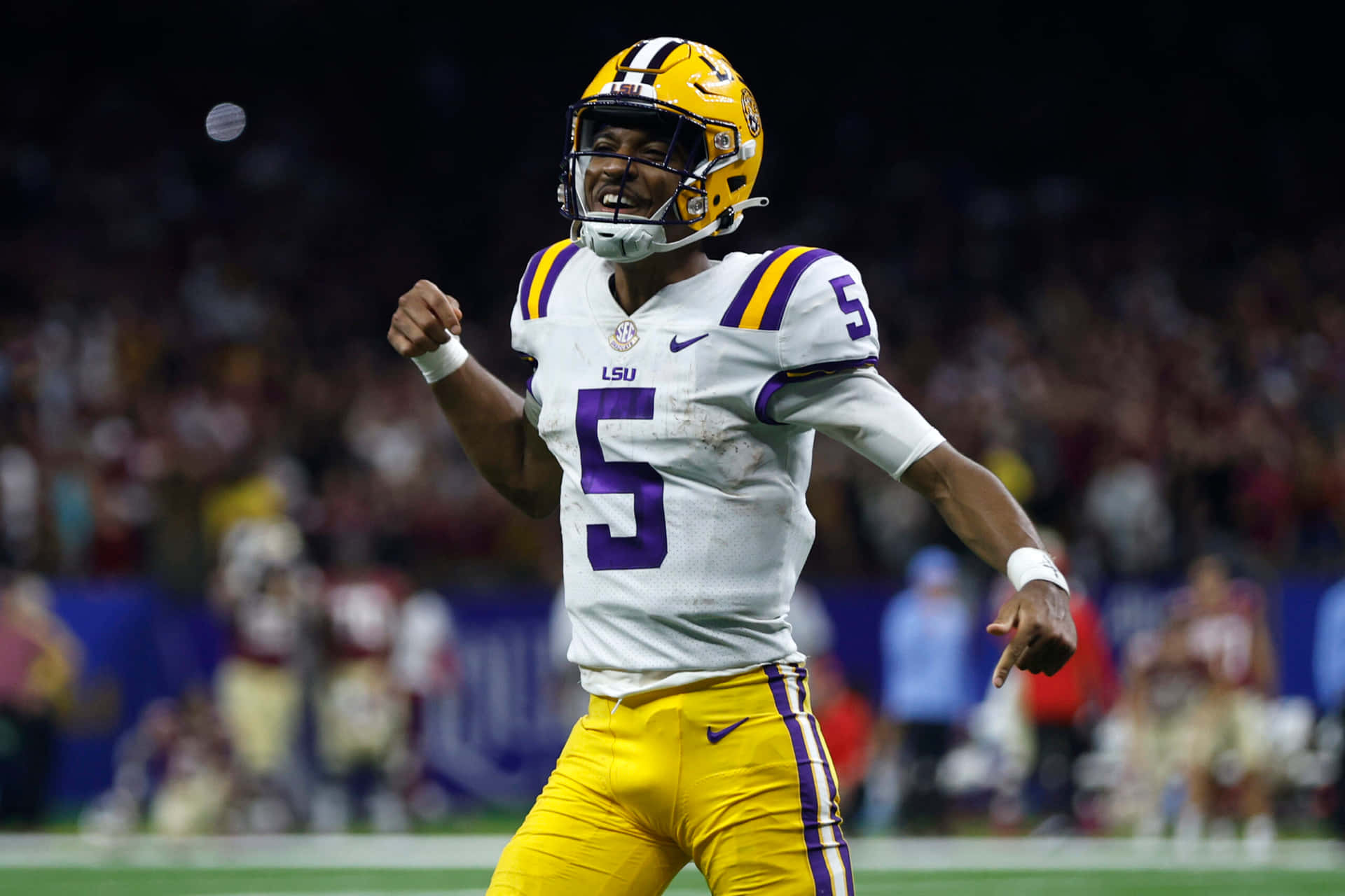LSU 足球運動員 5 號在夜間進攻後慶祝。
