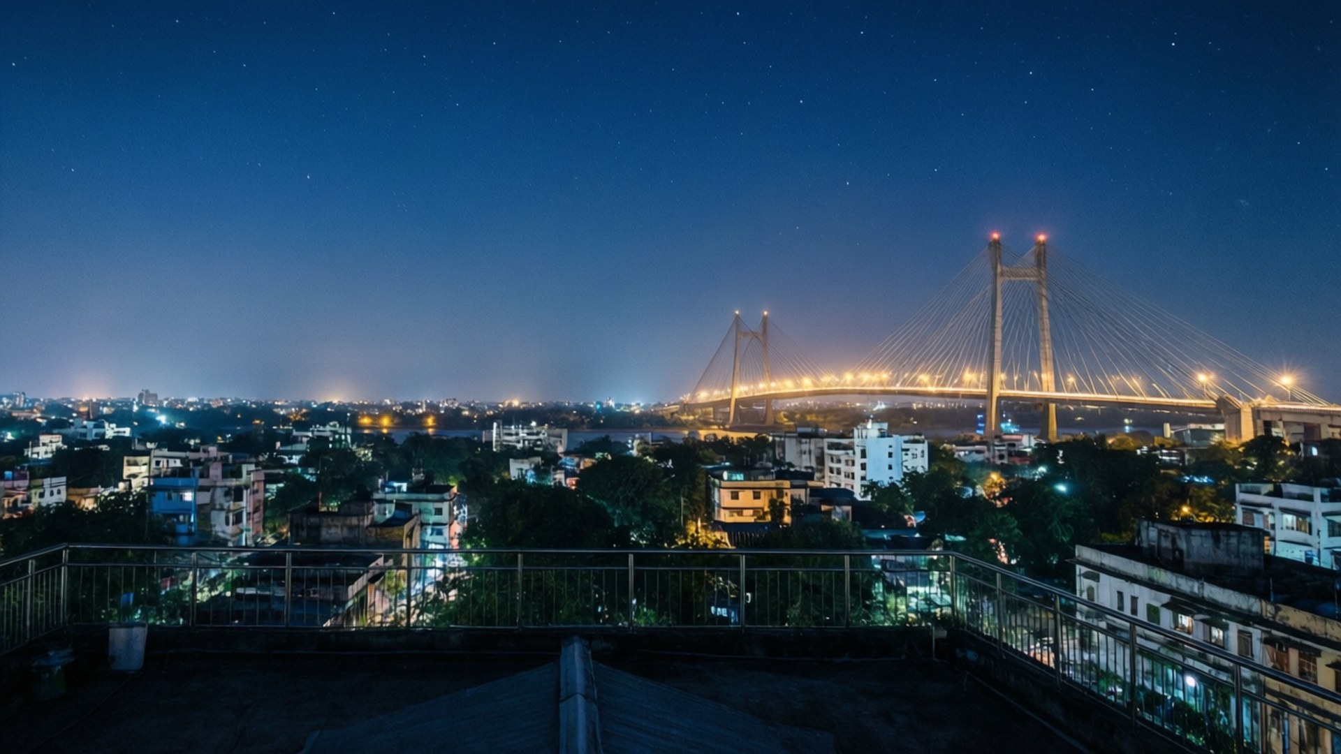 屋頂夜景，顯示照亮橋樑橫跨河流，城市燈光和星空