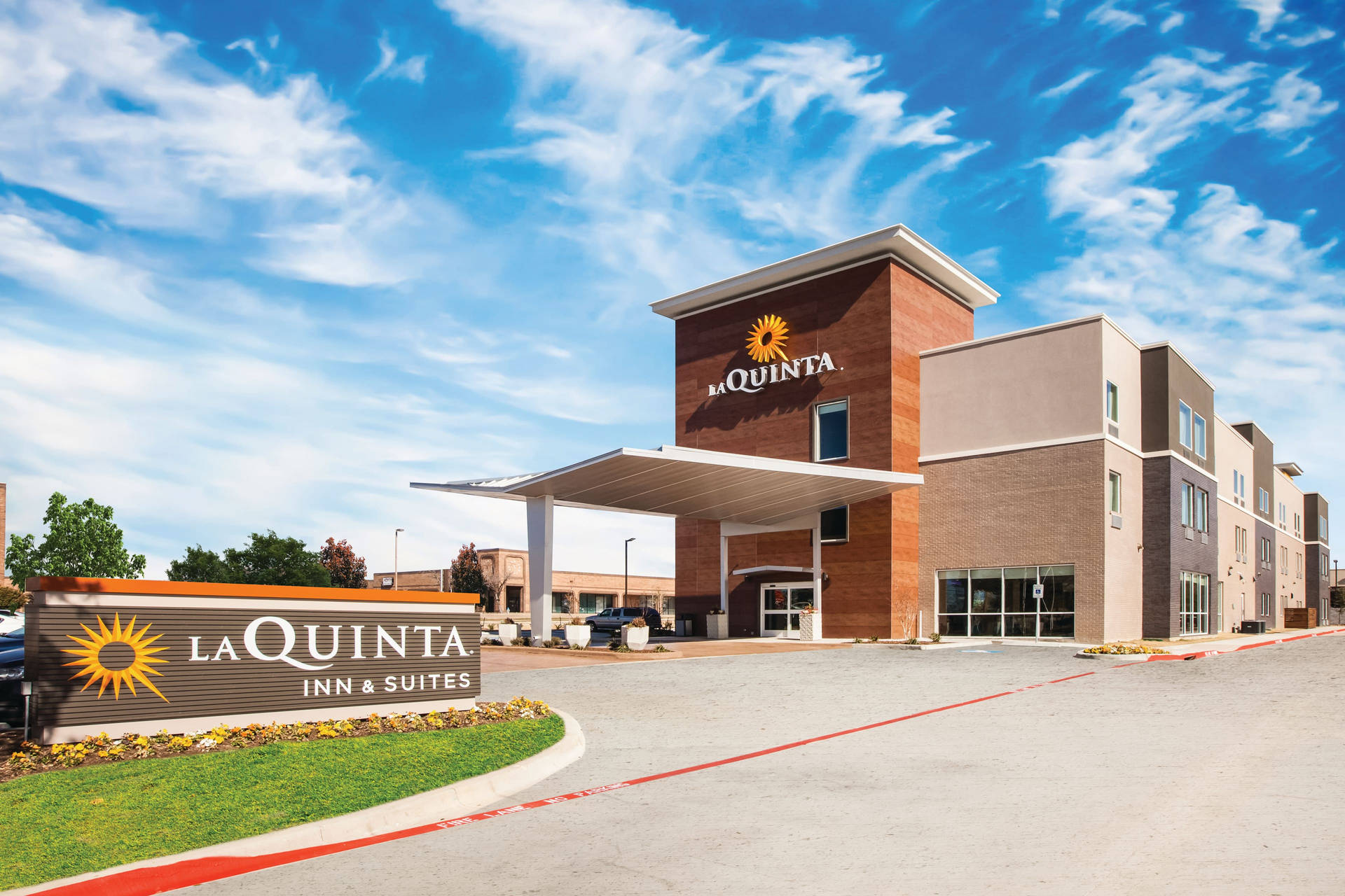 La Quinta Inn & Suites酒店，磚砌外牆，藍天下有大型標誌。