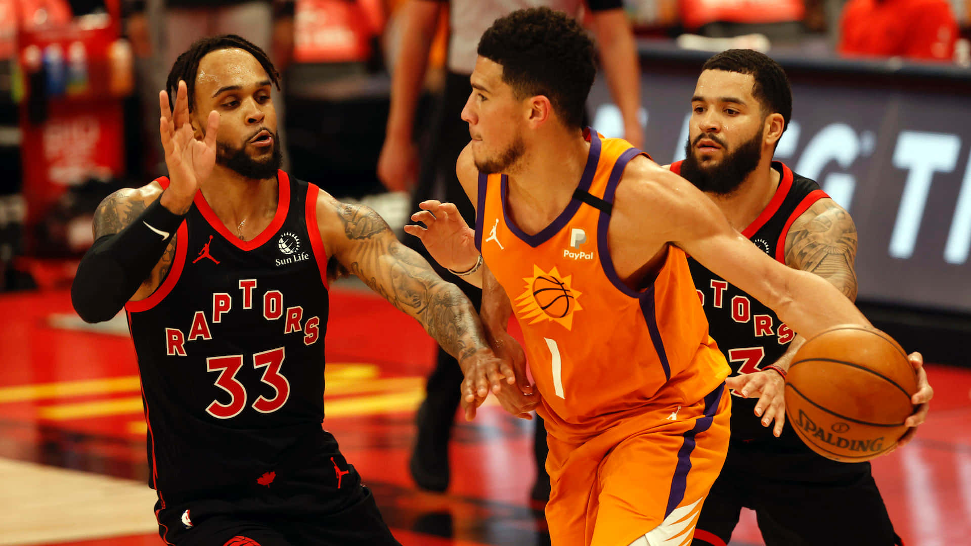 NBA籃球運動員在比賽中行動，防守球員緊盯持球者。