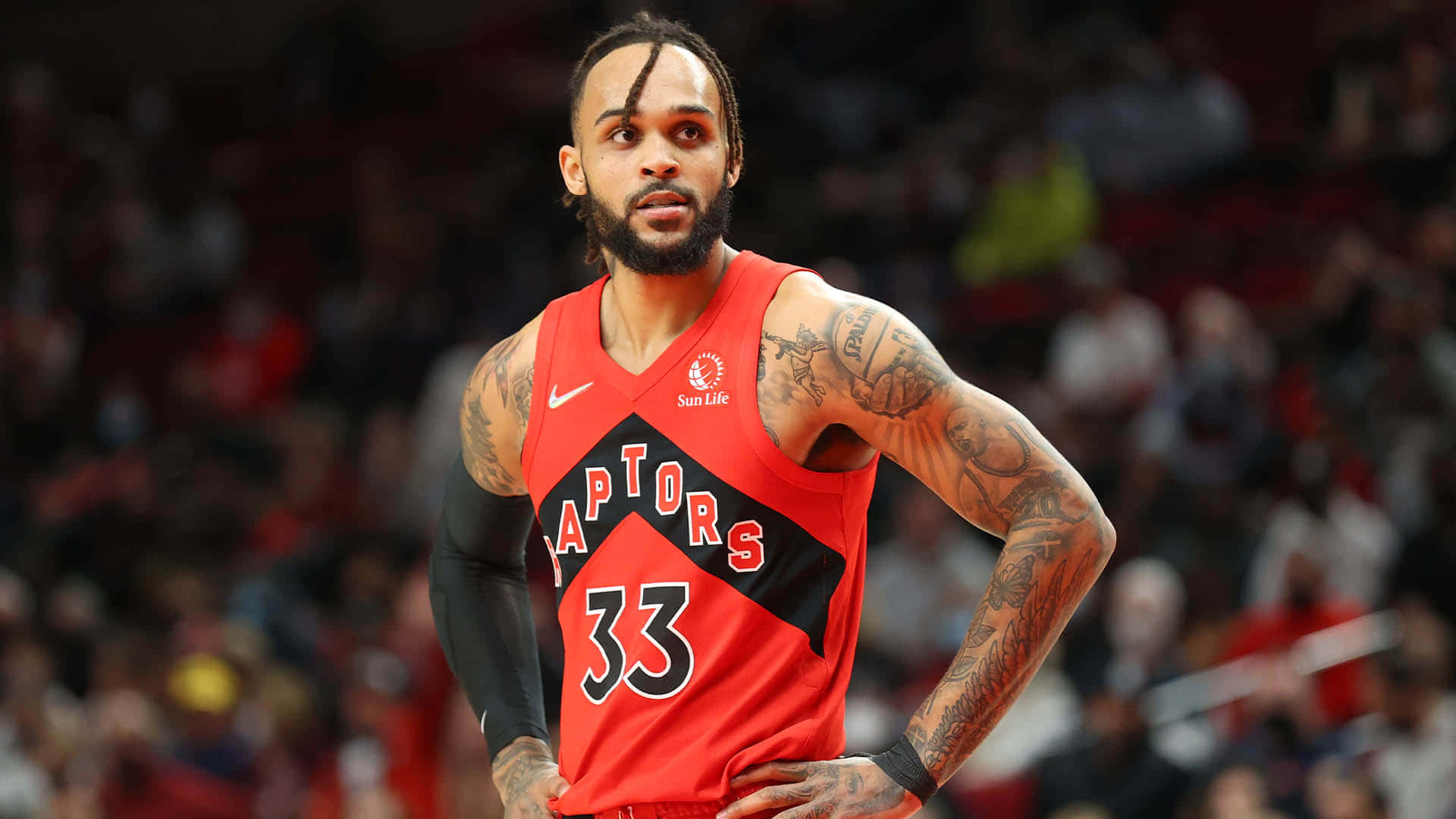 職業籃球運動員在球場上穿著紅色Raptors球衣，背號33。