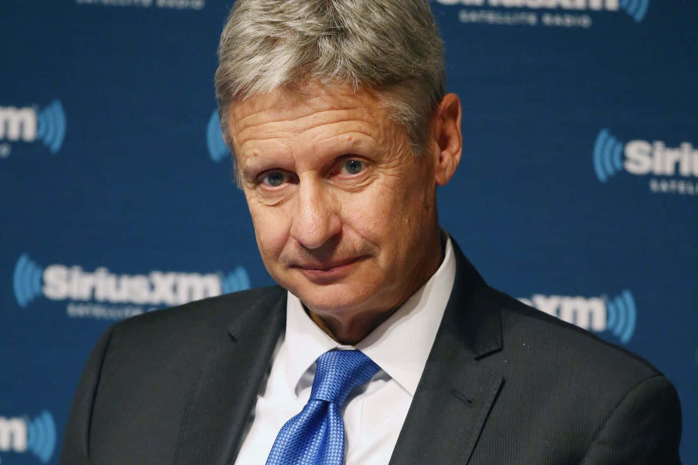 在SiriusXM活動中穿著西裝和藍色領帶的男士