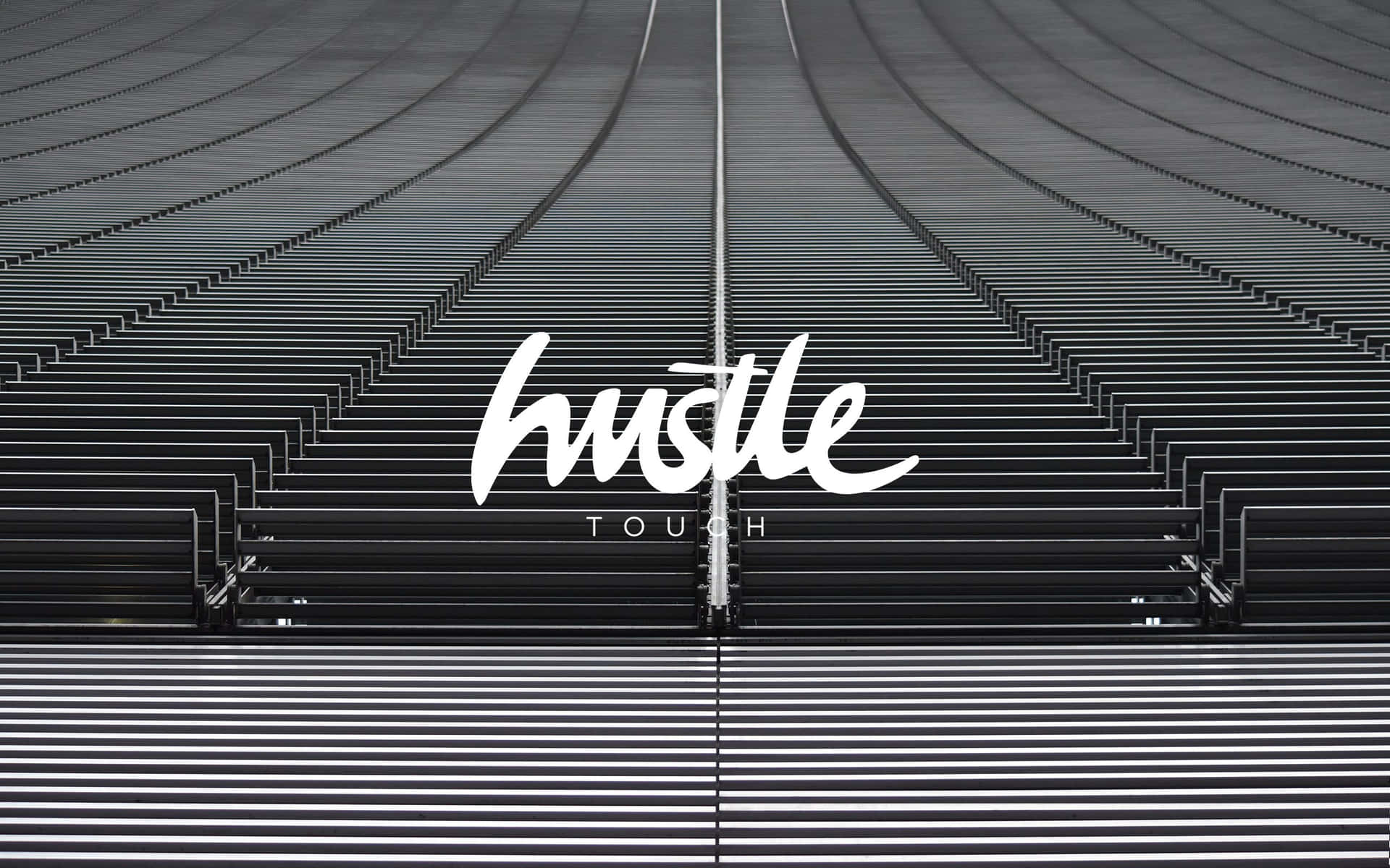黑色體育館座位，帶有白色文字寫著 hustle touch