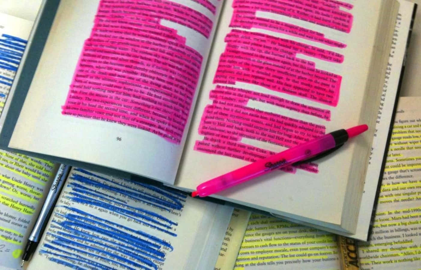 勇敢躍入聚光燈下 壁紙 — 一本打開的書，帶有粉紅色和藍色突出顯示的文字，以及一支粉紅色筆放在頁面上。