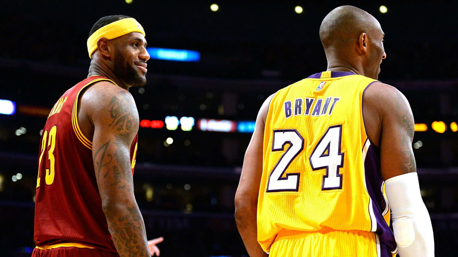兩位NBA傳奇人物穿著球衣在籃球場上對峙。