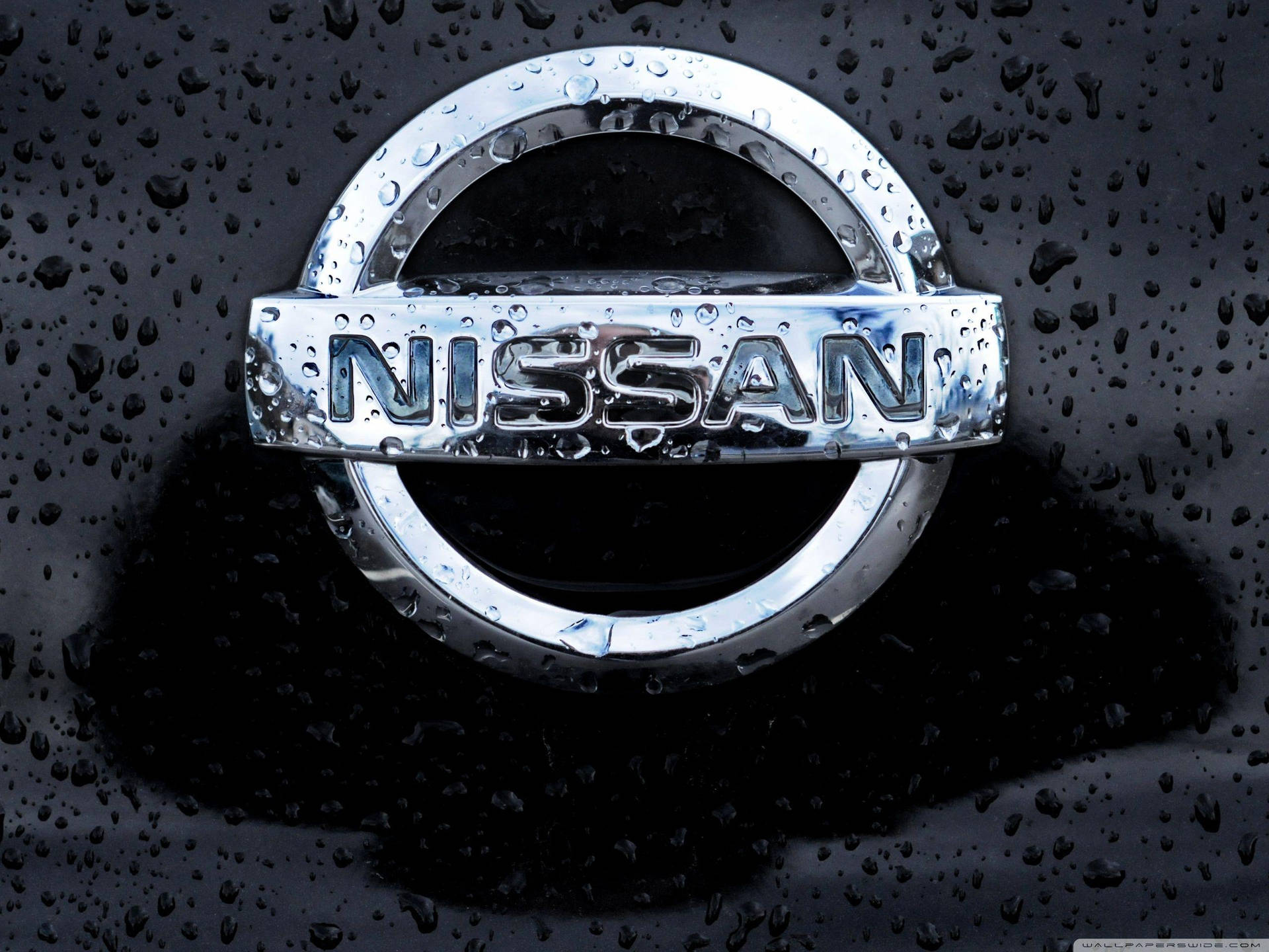 黑色表面上帶有雨滴的日產汽車標誌。