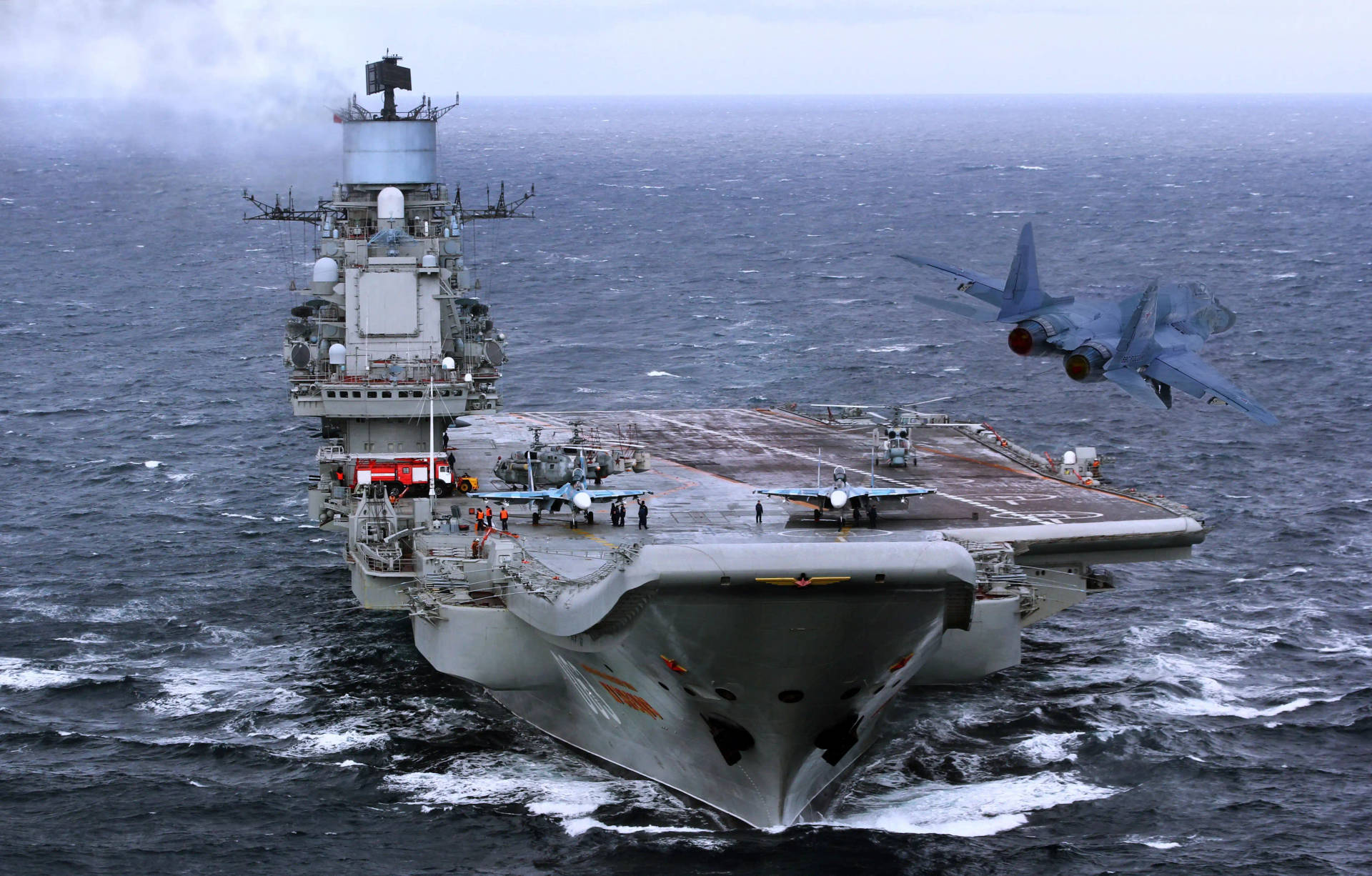 軍用航空母艦在波濤洶湧的海面上發射噴射機。