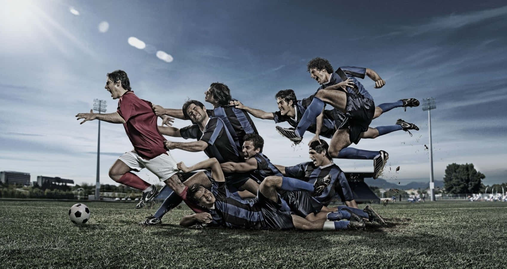 3d Sports 桌布 壁紙 — 動態足球員在陽光普照的場地上空中碰撞，頭頂上體育場燈光閃爍。