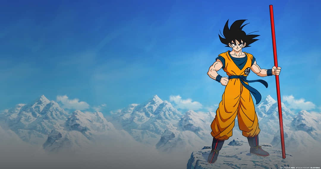 Dbz Movies 桌布 壁紙 — 動漫戰士悟空站在白雪覆蓋的山頂上，手持紅色法杖，背景是清澈的藍天。