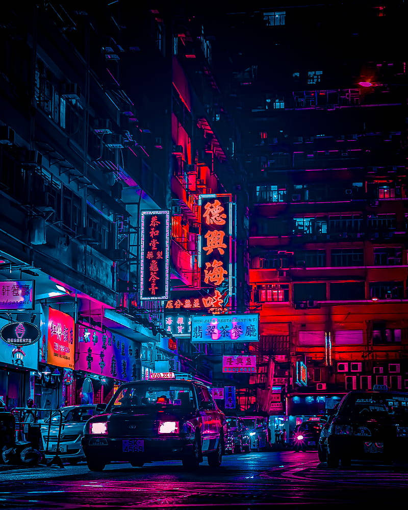 動漫風格 iPhone 街景 壁紙 — 夜晚被霓虹燈淹沒的城市小巷，發光的招牌映照在濕漉漉的人行道上，汽車沿著狹窄的街道停放。