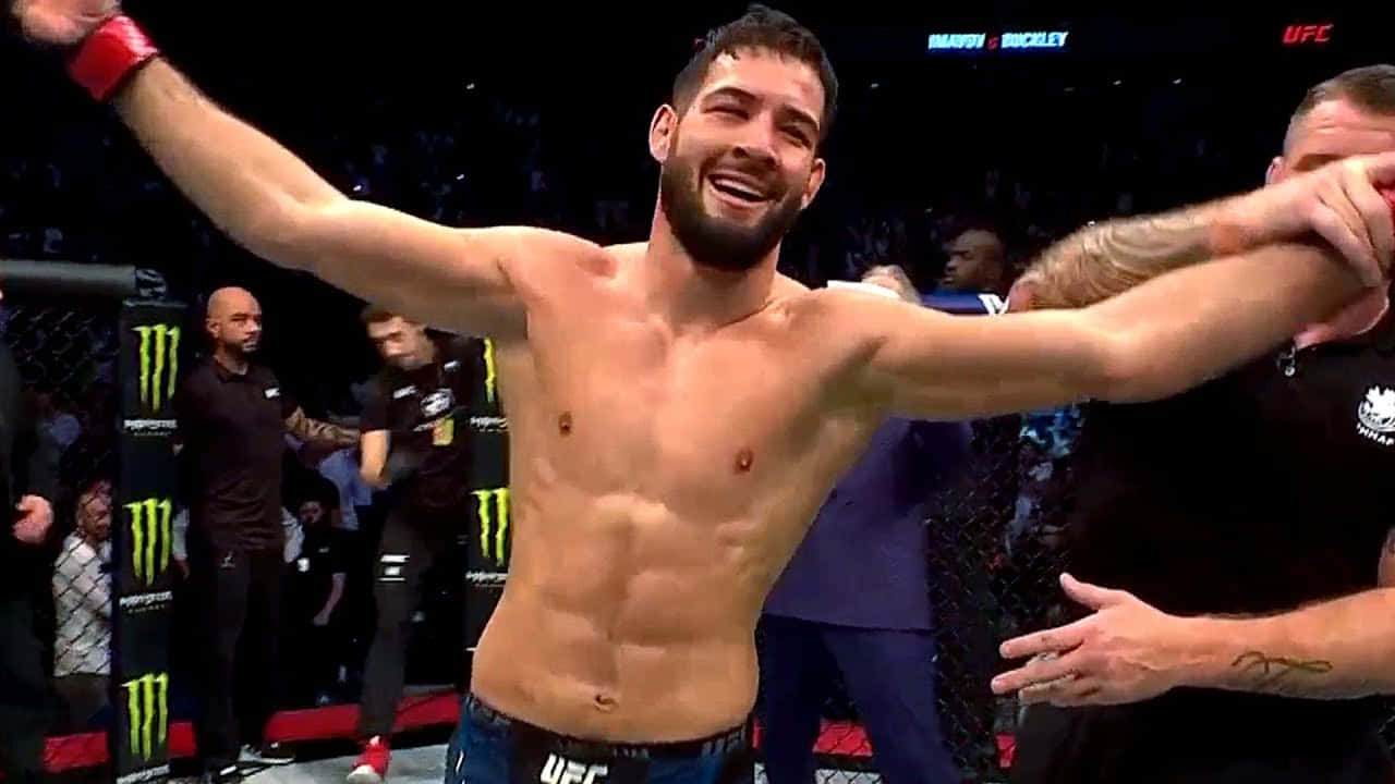 UFC拳手在八角籠中高舉雙臂慶祝勝利。