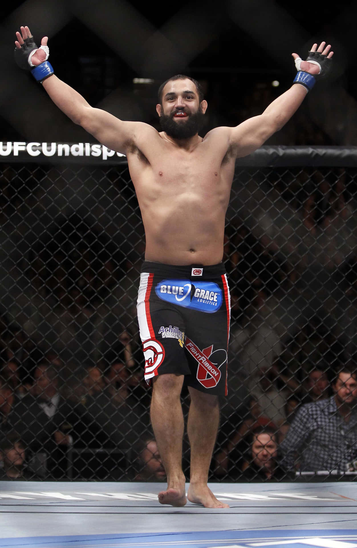 MMA拳手在UFC八角籠內舉臂慶祝勝利