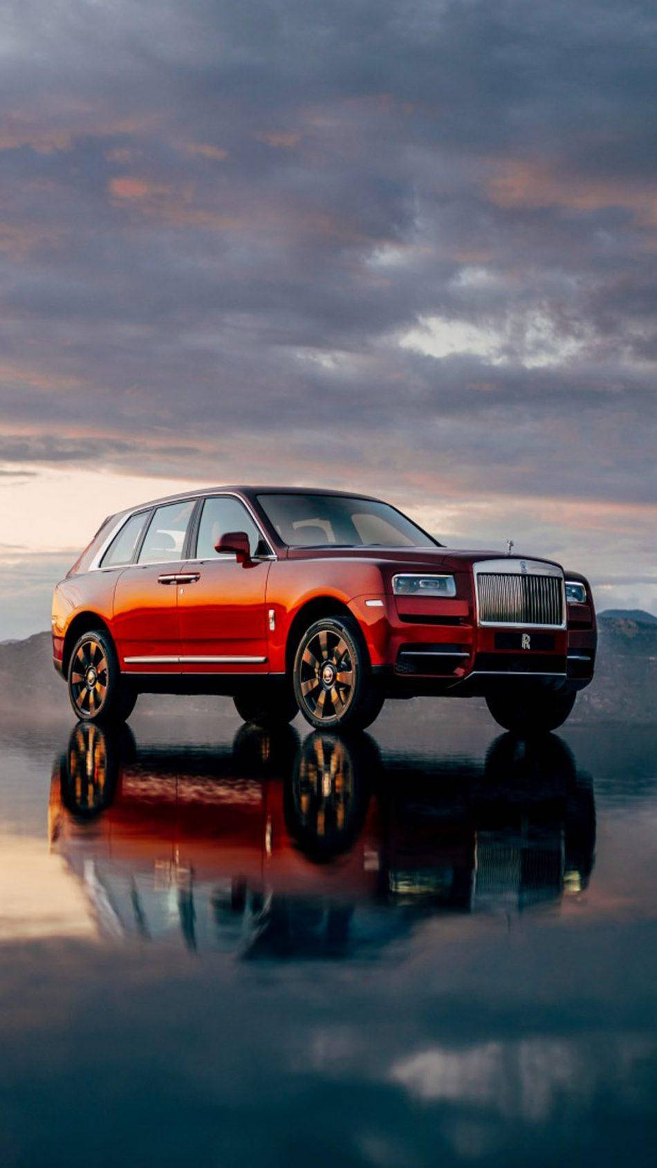 紅色勞斯萊斯 Cullinan SUV 在潮濕路面上反射（日落時分）。